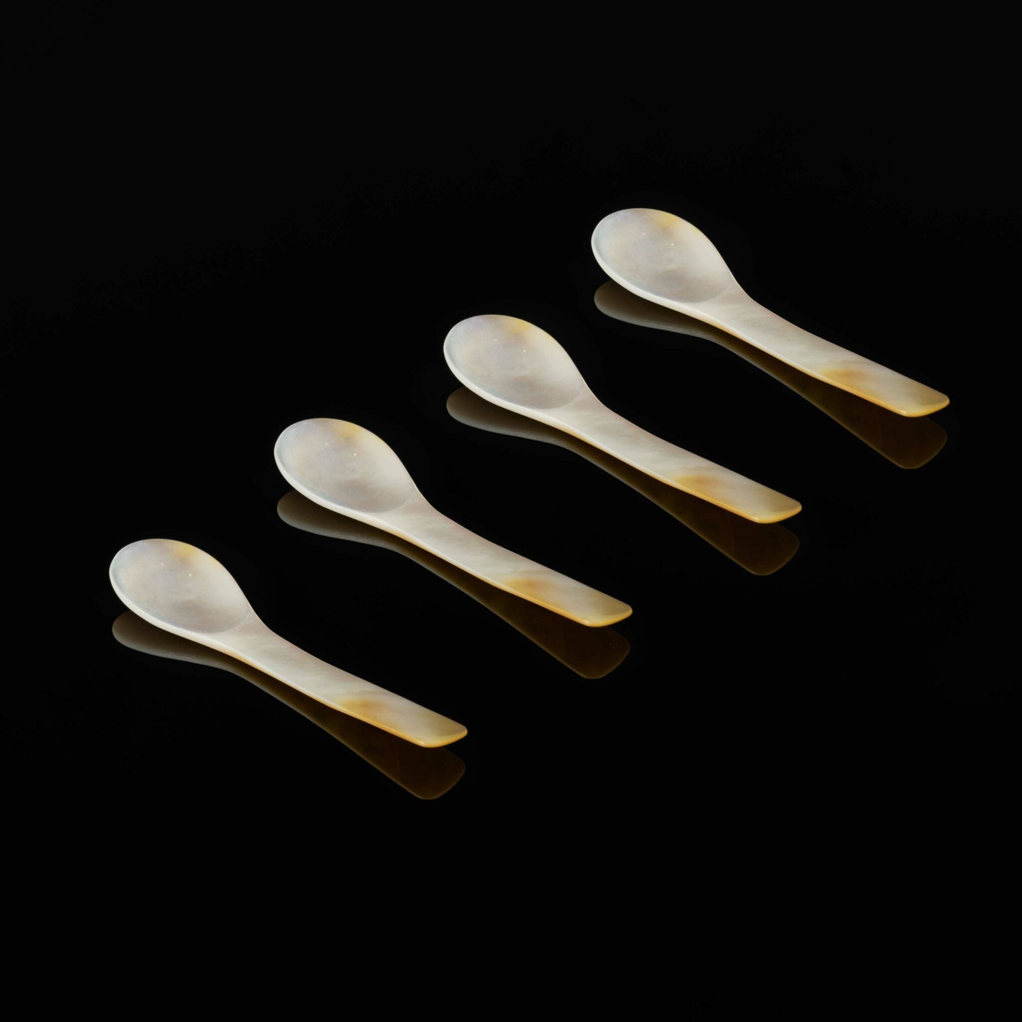 Set med fyra handgjorda pärlemorskedar – klassiskt tillbehör till caviarservering.