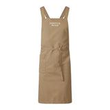 Khakifärgat sandfärgat Pontus kockförkläde med ergonomiska axelband, helfigur framifrån.